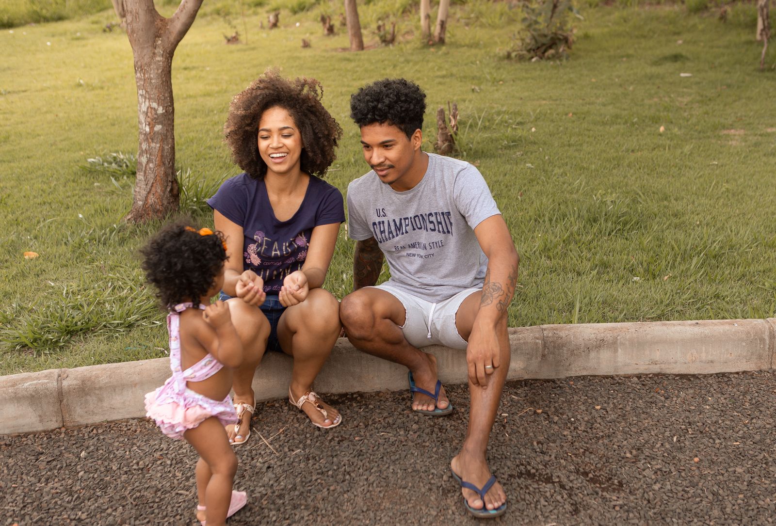Des parents jouent avec leur enfant dans un parc